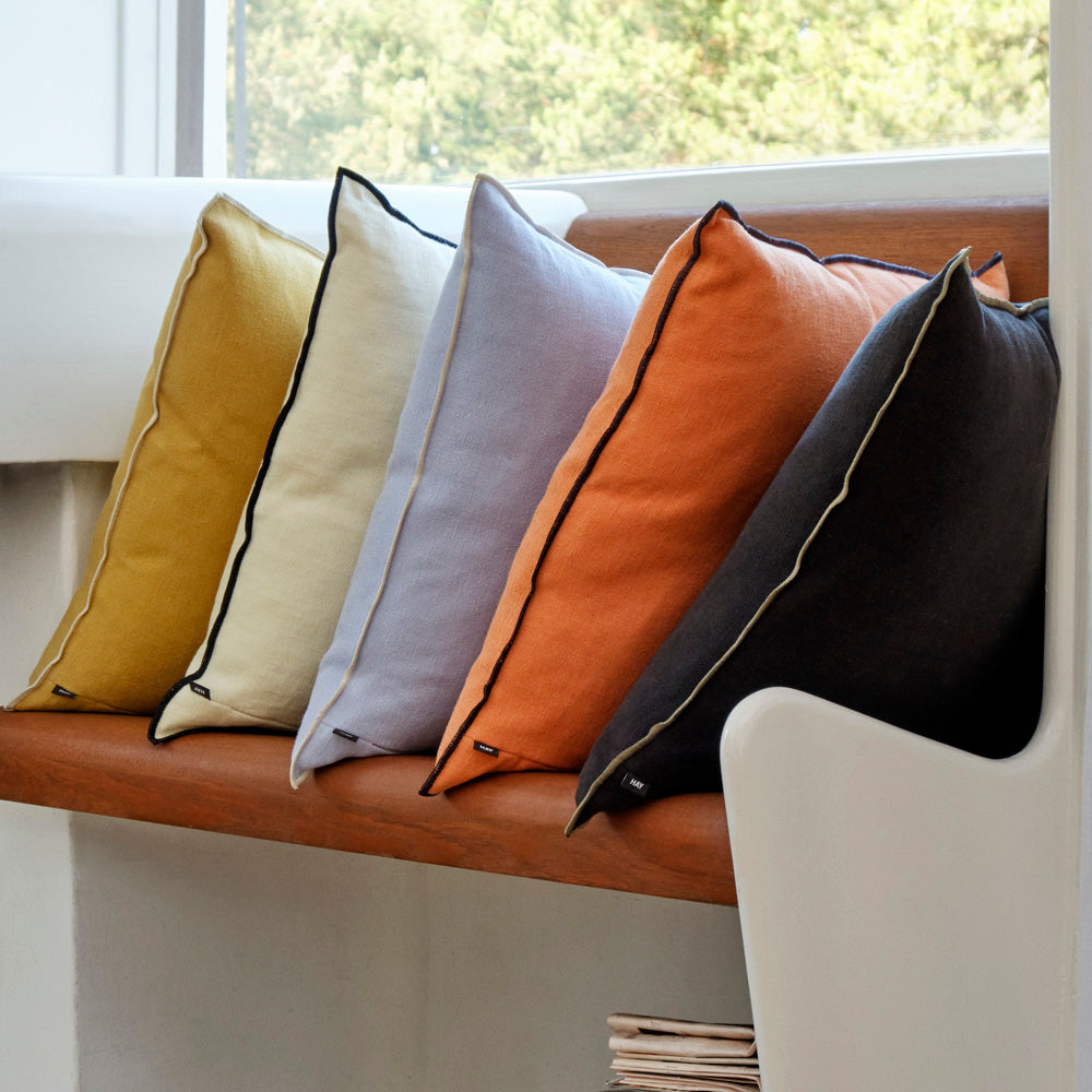 The chic Outline Cushion from HAY features a classic design with a contemporary colour twist. Made in a beautiful cotton-linen blend, the cushion has a contrasting piped trim around the edges to create a more defined silhouette. 